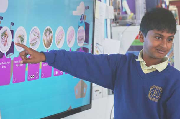 School child pointing at a screen